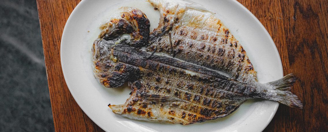 birds eye view shot of a grilled fish on a plate - The pass